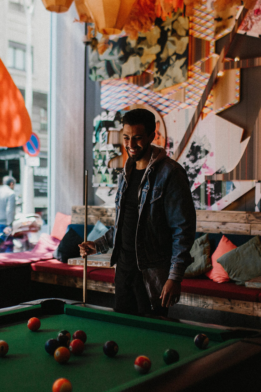 Topdeck traveler playing pool in a trendy cafe in New York City.