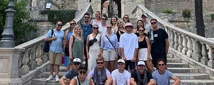 Topdeck Tour group posing for a photo in front of the entrance to a medieval fort.