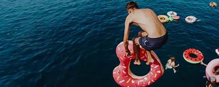 Topdeck traveler jumping off the deck with an inflatable ring to join the rest of the tour group.