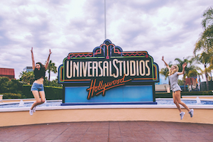 Topdeck travelers posing beside Universal Studios sign.