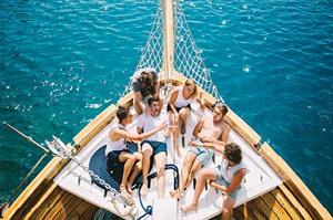 Topdeck travelers relaxing at the bow of a sailing boat on a sailing tour in Croatia.