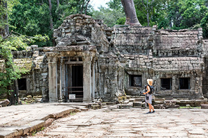 Topdeck traveler standing outside the ancient Ta Prohn Temple.