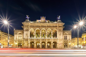 An old Vienna state building lit up at night.