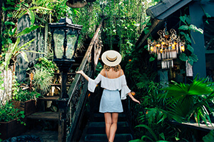 Topdeck traveler going up wooden stairway to a bar in Seminyak, a popular destination in Southern Bali.