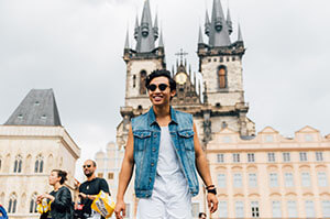 Topdeck traveler posing for a photo with part of Prague Castle in the background.