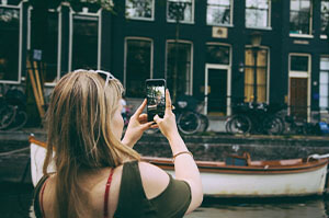 Topdeck traveler taking a picture of the Anne Frank House in Amsterdam.