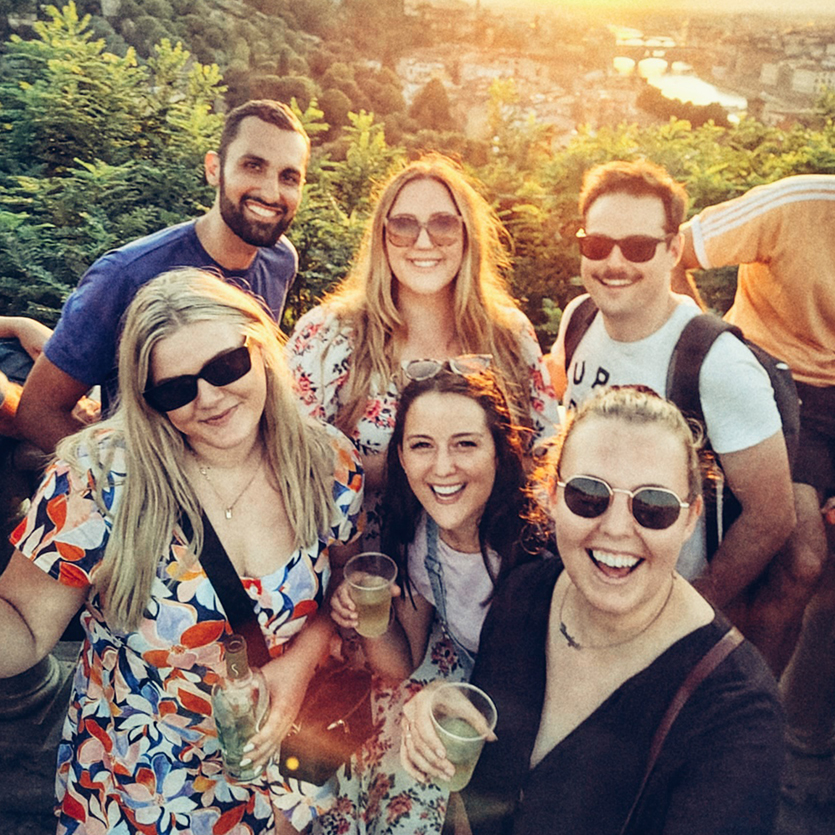 A topdeck tour group posing for a picture on a forested hillside while on a hike near Prague.