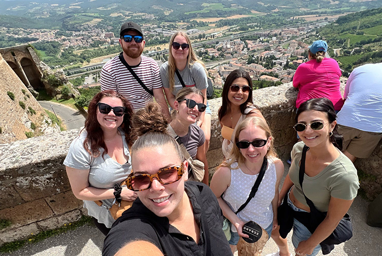 Topdeck tour group posing for a photo together with the city of Florence in the background.