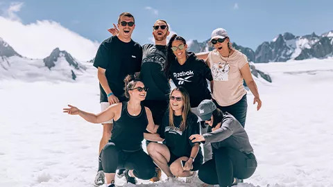 Group of people standing together on the ice of a glacier in New Zealand.