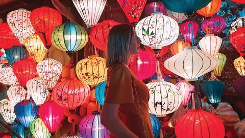 A woman looking at a Vietnamese silk lanterns