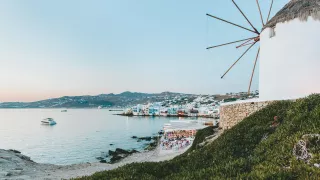 Windmill of Mykonos with the lights of Little Venice in the background.