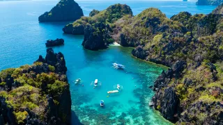 View of boat floating along the coastline in the blue waters of El Nido.