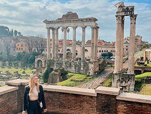 Topdeck traveler posing for a photo in front of the Roman Forum.