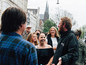 A Topdeck crew member going over the history of the city to the group of travelers. 