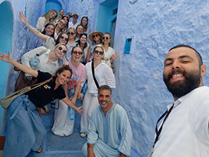 Topdeck tour group posing for a photo at the famous Blue Steps of Chefchaouen.