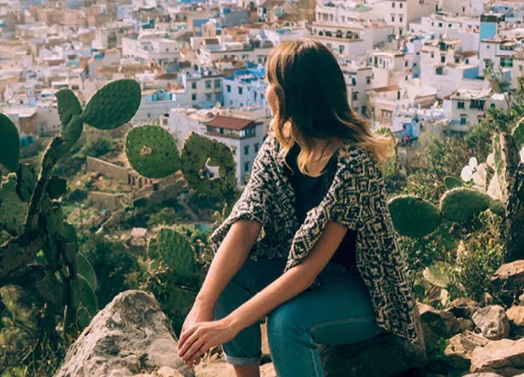 Topdeck Traveler on hillside overlooking an oasis town in Morocco.