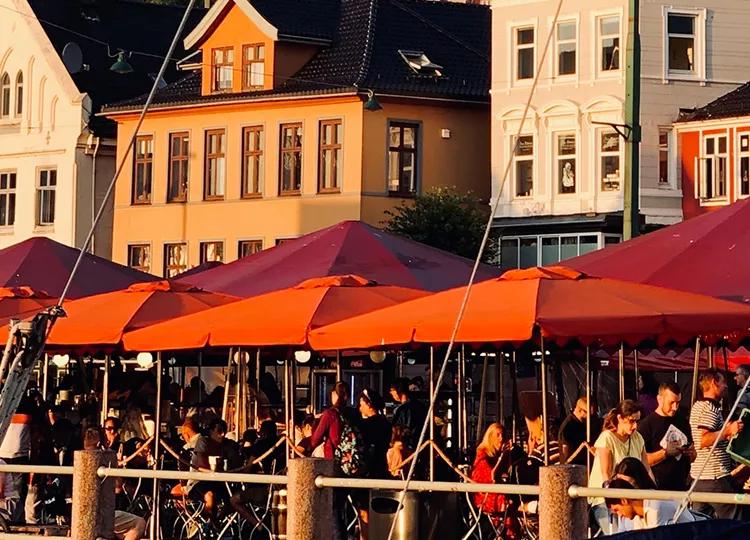 Restaurant patrons eating outside by the dockside in Bergen.