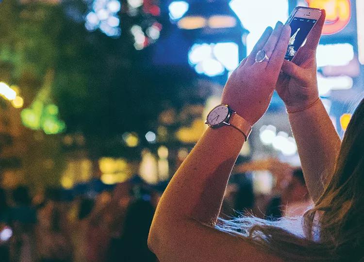 Topdeck Traveler taking a picture of the casinos on the Las Vegas strip with her phone. 