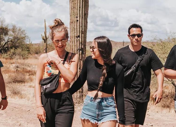 Topdeck Group standing in the Arizona desert in front of a cactus.