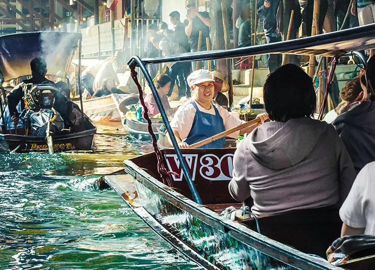 Boats filled with customers and traders fill the canals of the Damnoen Saduak floating market in Western Thailand.