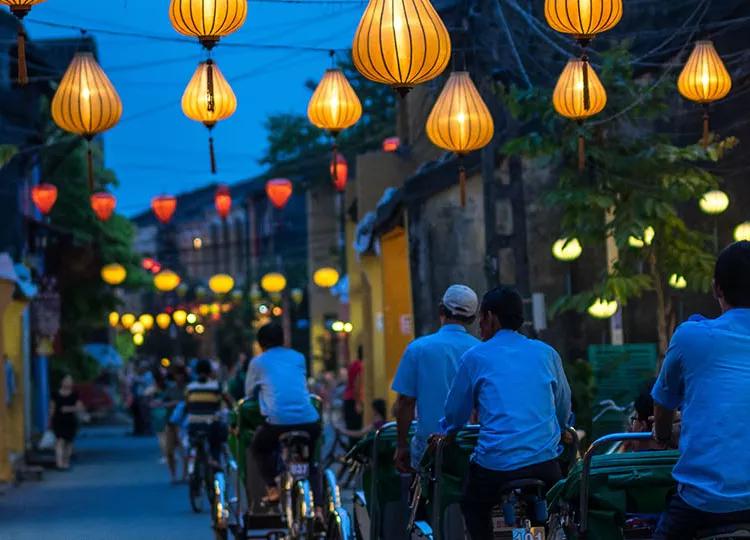 Locals cycle down the lantern lit streets of Hoi An in Vietnam.