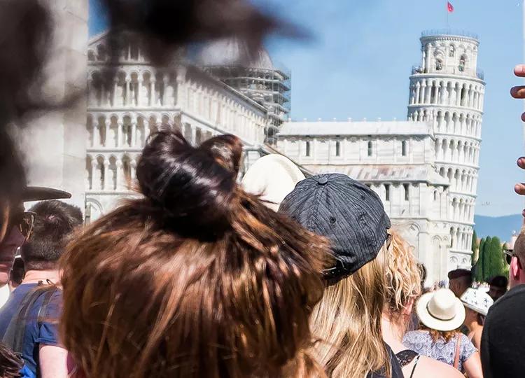 Topdeck Travel tour group heading to the Piazza del Duomo, with the Leaning Tower of Pisa in the background.