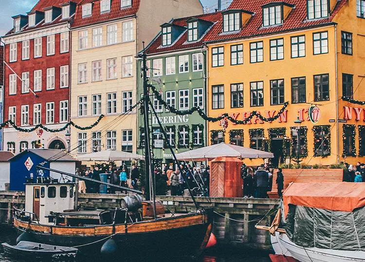 Boats and colorful houses line the docks of Nyhavn harbour in Copenhagen.