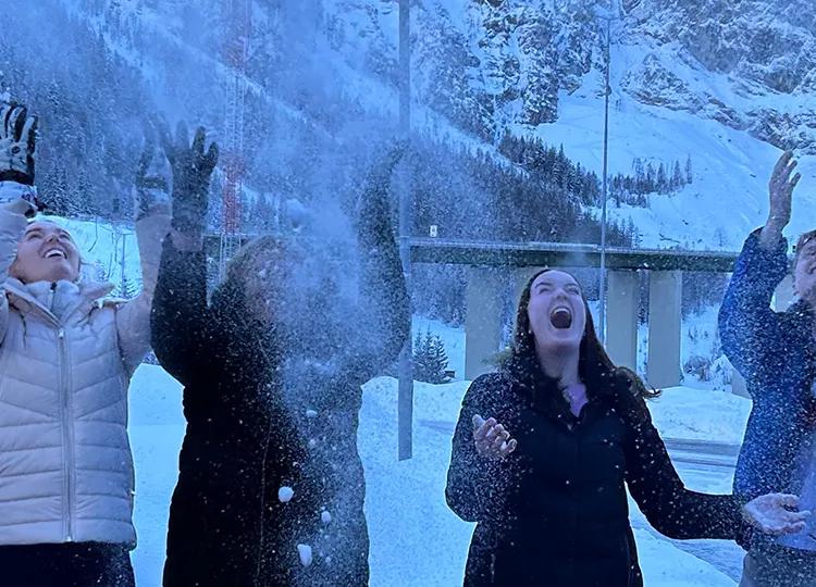 Topdeck group playing around and throwing snow in the air during a trip through the Swiss Alps.