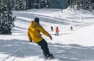 A picture of a Topdeck tour group, snowboarding and skiing down the mountains of Whistler.