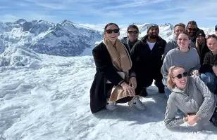 Topdeck tour group taking a group photo atop the Swiss Alps.