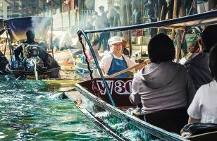 Boats filled with customers and traders fill the canals of the Damnoen Saduak floating market in Western Thailand.