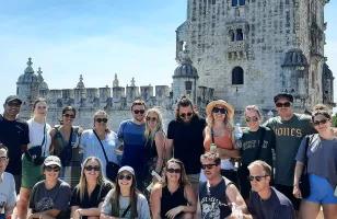 Topdeck tour group posing for a photo in front of Lisbon’s famous Torre De Belem Tower.