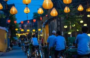 Locals cycle down the lantern lit streets of Hoi An in Vietnam.