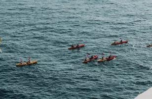 Topdeck travelers rowing out of the port of Dubrovnik in canoes to the crystal blue waters of the Dalmation Coast.