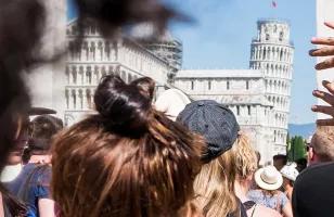 Topdeck Travel tour group heading to the Piazza del Duomo, with the Leaning Tower of Pisa in the background.