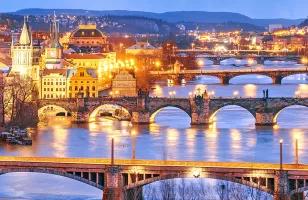 A view of the bridges leading out of Prague, lit up at night.