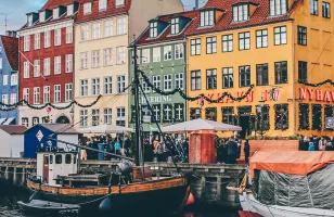 Boats and colorful houses line the docks of Nyhavn harbour in Copenhagen.