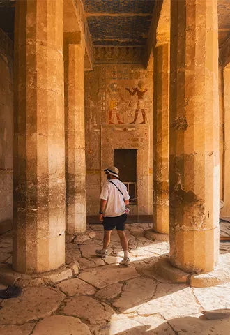 Person walking between pillars of the Mortuary Temple of Hatshepsut.