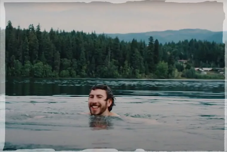 Topdeck traveler taking a swim in a lake in North America.